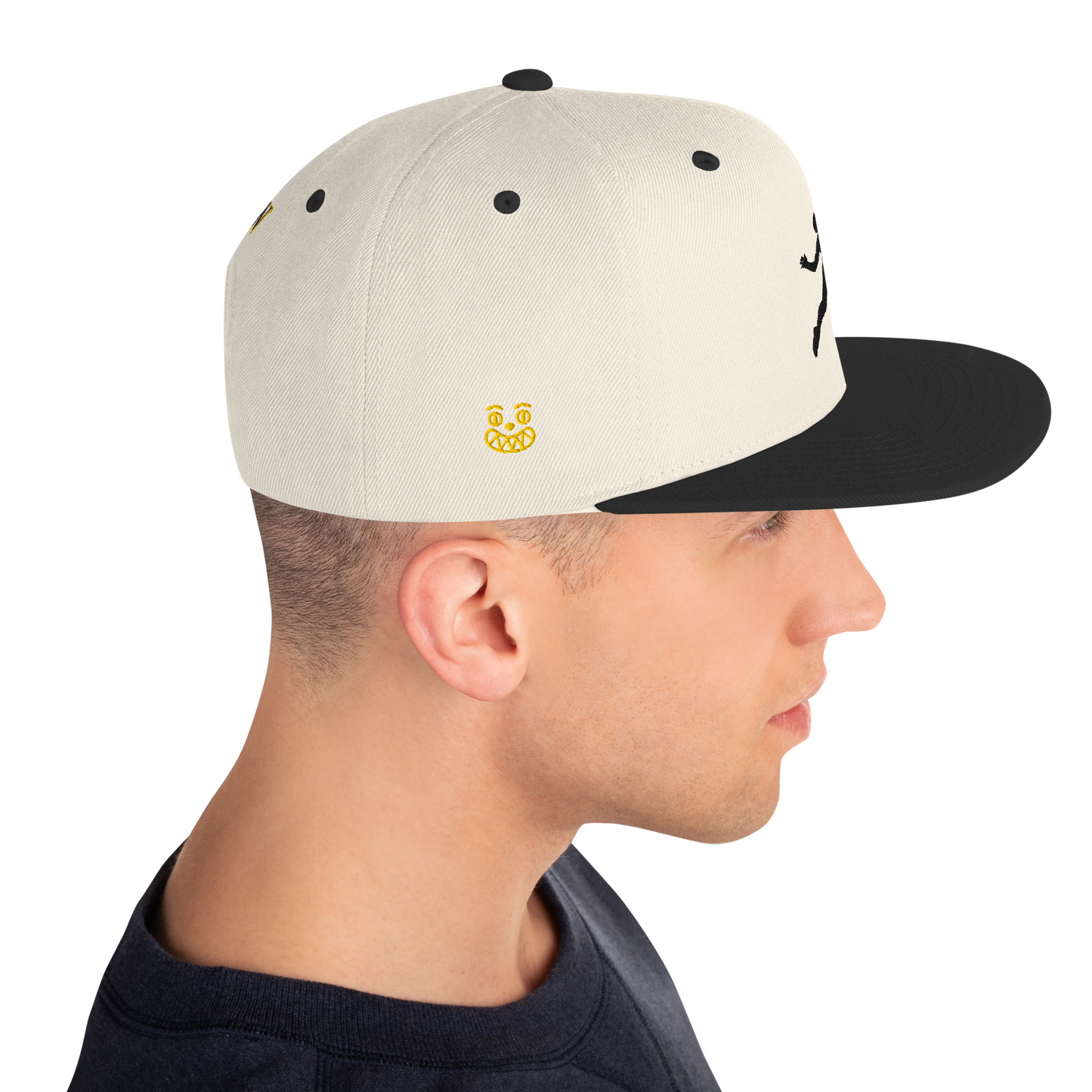 Snapback cap with off-white front panel, small yellow logo, black brim and side stitching