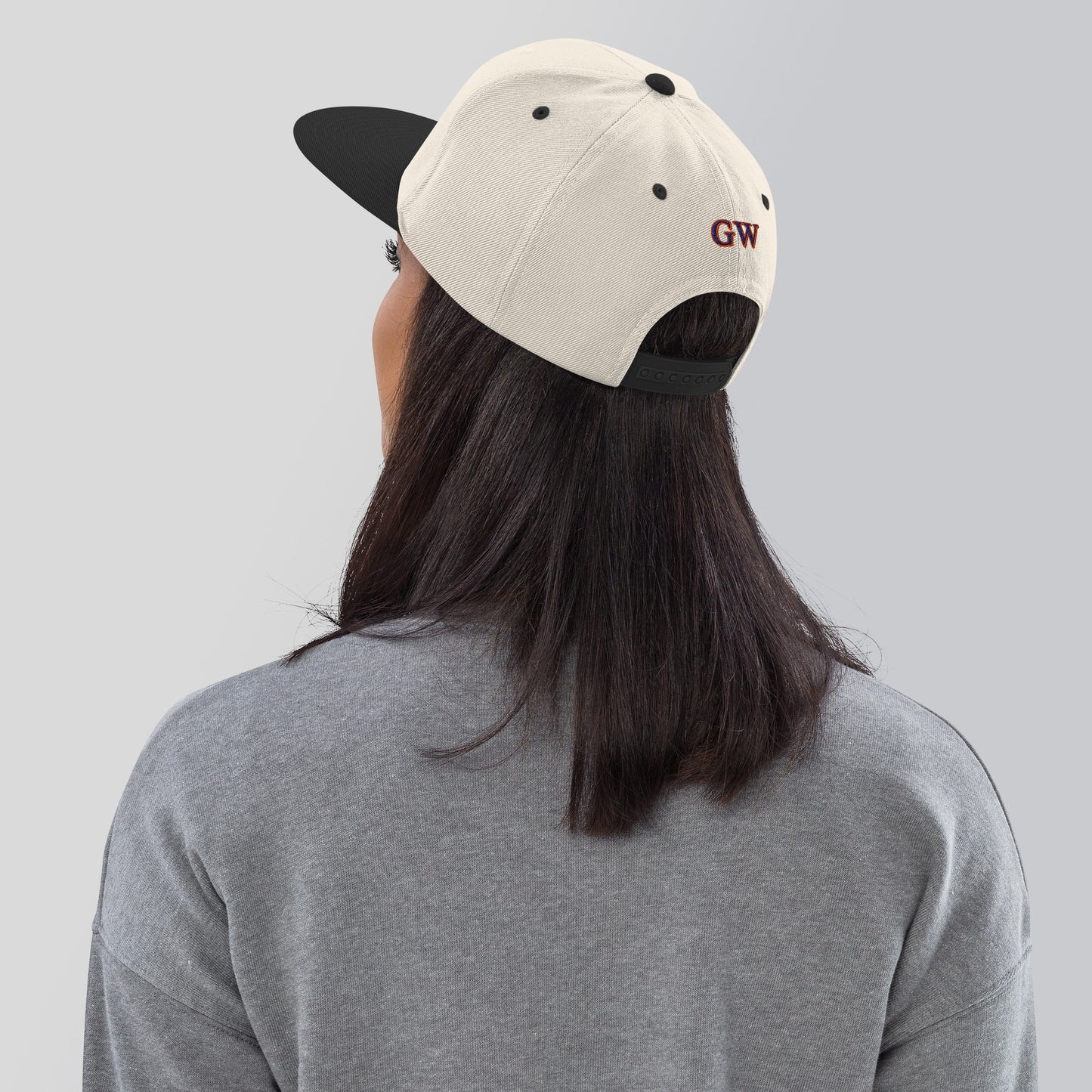 Cremefarbene Snapback-Kappe mit schwarzem Schirm, hinten "GW"-Logo sichtbar