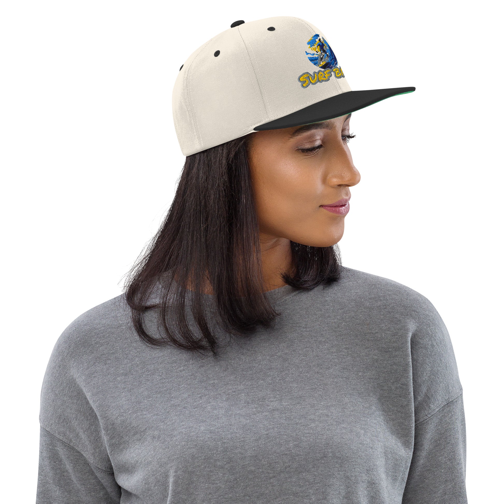 Cremefarbene Snapback-Kappe "Surf Baby" mit schwarzem Schirm, getragen von vorne